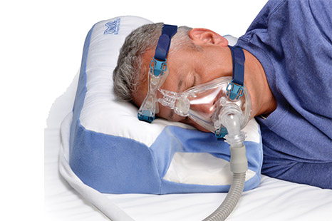 Image of a man with a CPAP mask on using the CPAP Pillow 2.0 product.