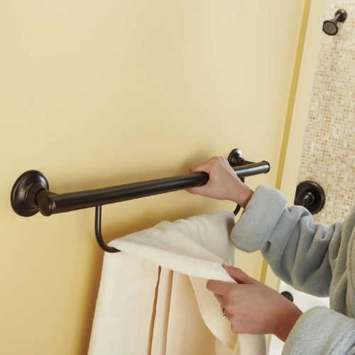 Image of person holding onto multi-purpose grab bar with towel holder.