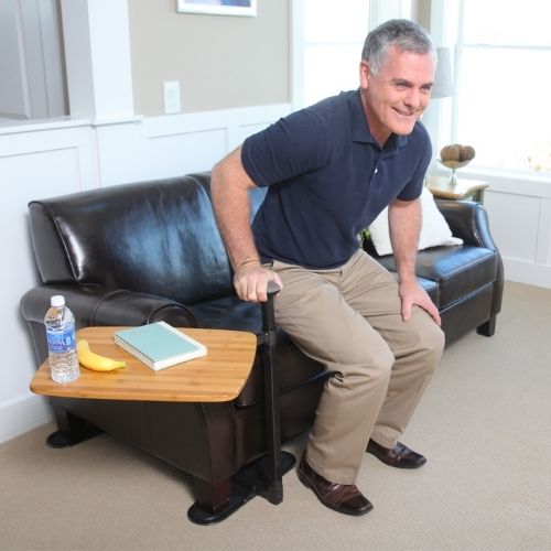 Image of man standing up from couch with Omni Tray next to him.