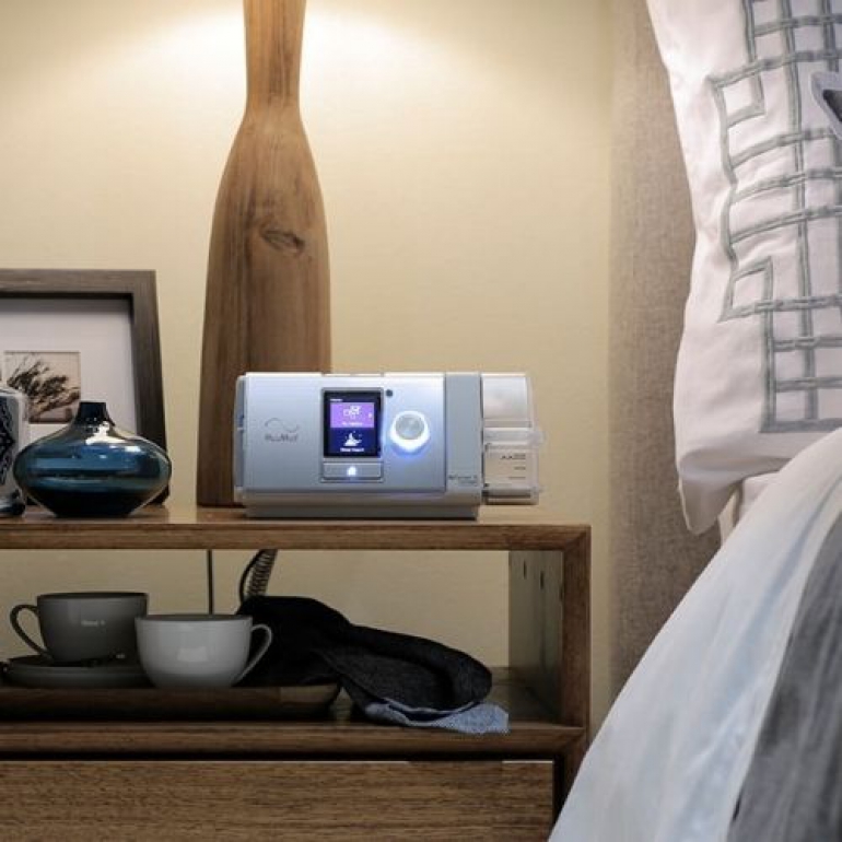 Image of the ResMed AirSense 10 Autoset on a bedside table.