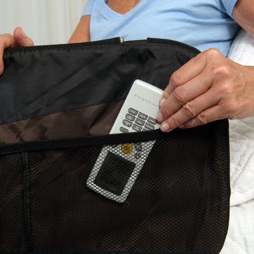 Woman putting remote in Stander EZ Adjust Bed Rail pouch.