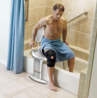Man using transfer bench to transfer himself into tub. thumbnail