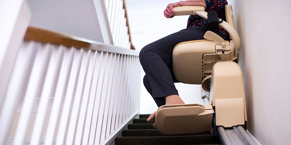 A woman who has a stairlift in her home after receiving a stair lift assessment